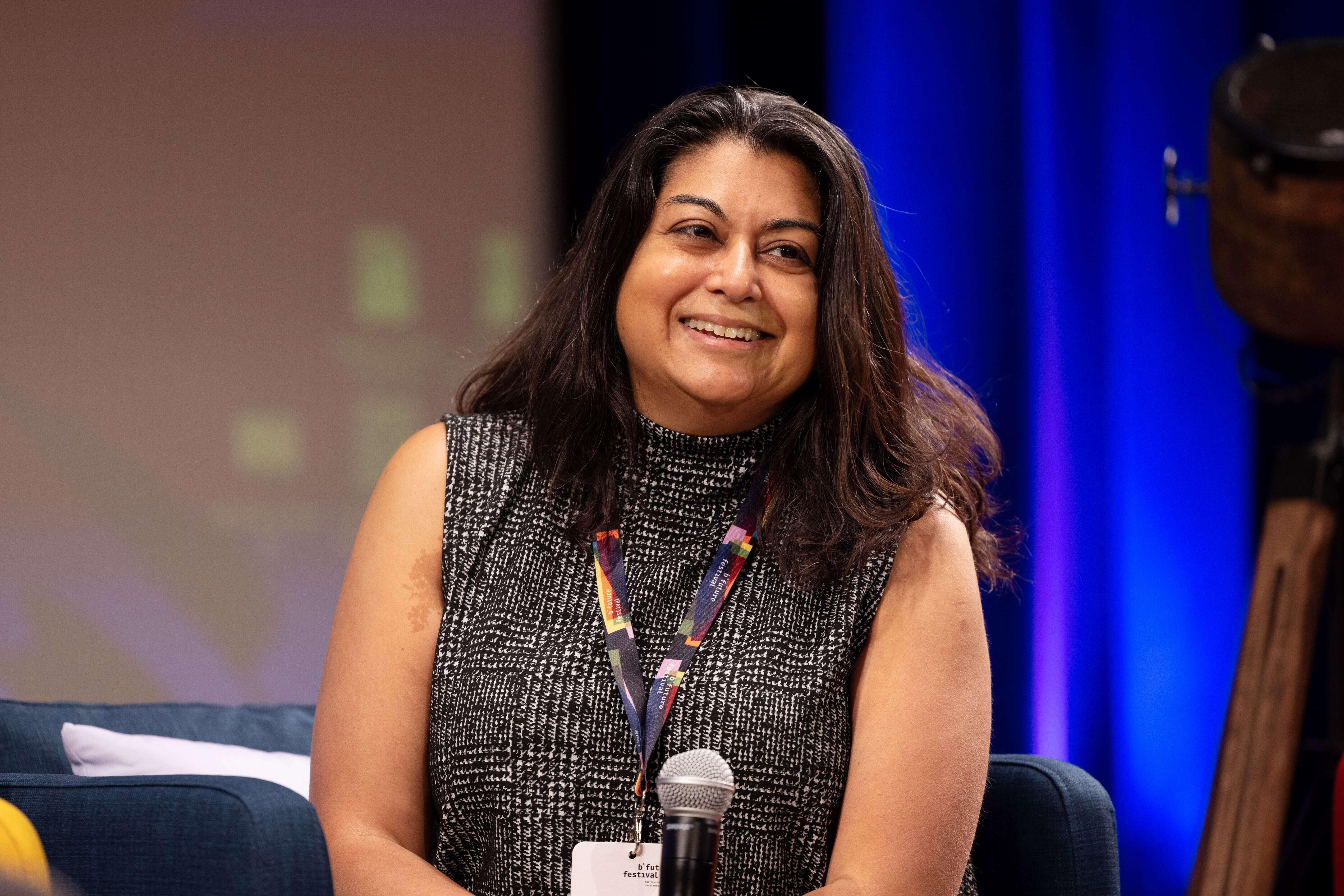 Aparna Mukherjee, Chief Programs Officer bei Resolve Philliy, beteiligt sich an einer Podiumsdiskussion und lächelt freundlich
