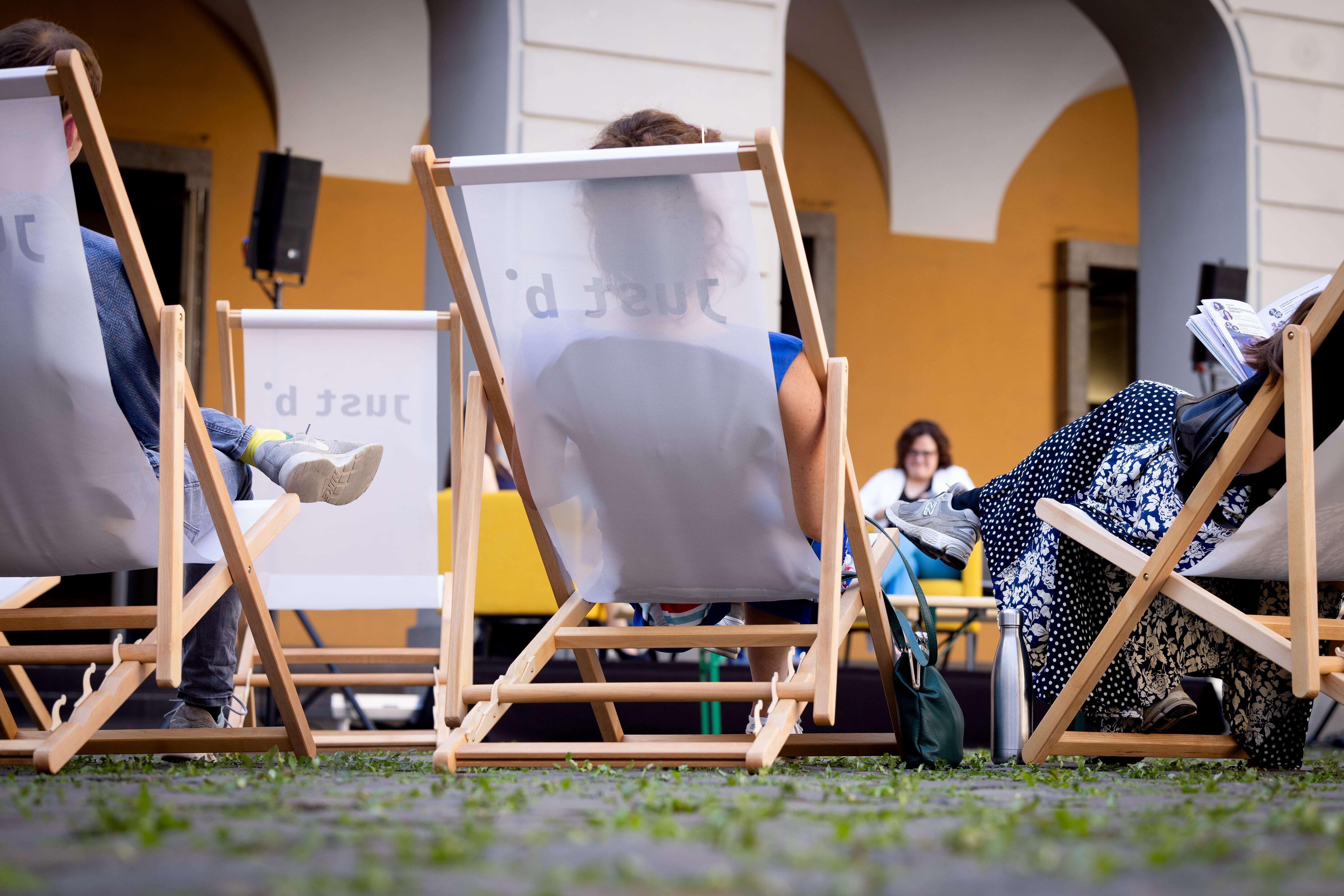 Von hinten sieht man weiße Liegestühle mit Besucherinnen und Besuchern des b° future festivals, die dem Ask-me-anything zuhören.