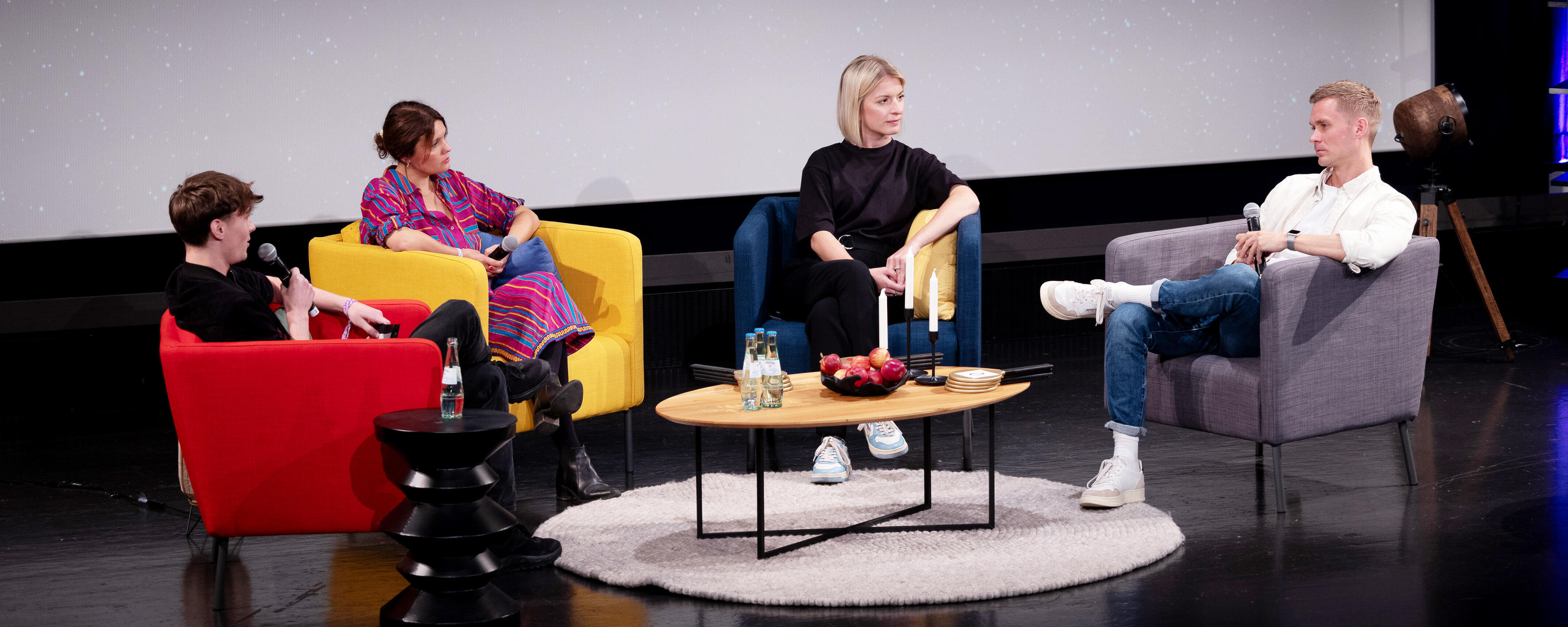 Vier Menschen sitzen auf der b° future Bühne und halten einen Talk