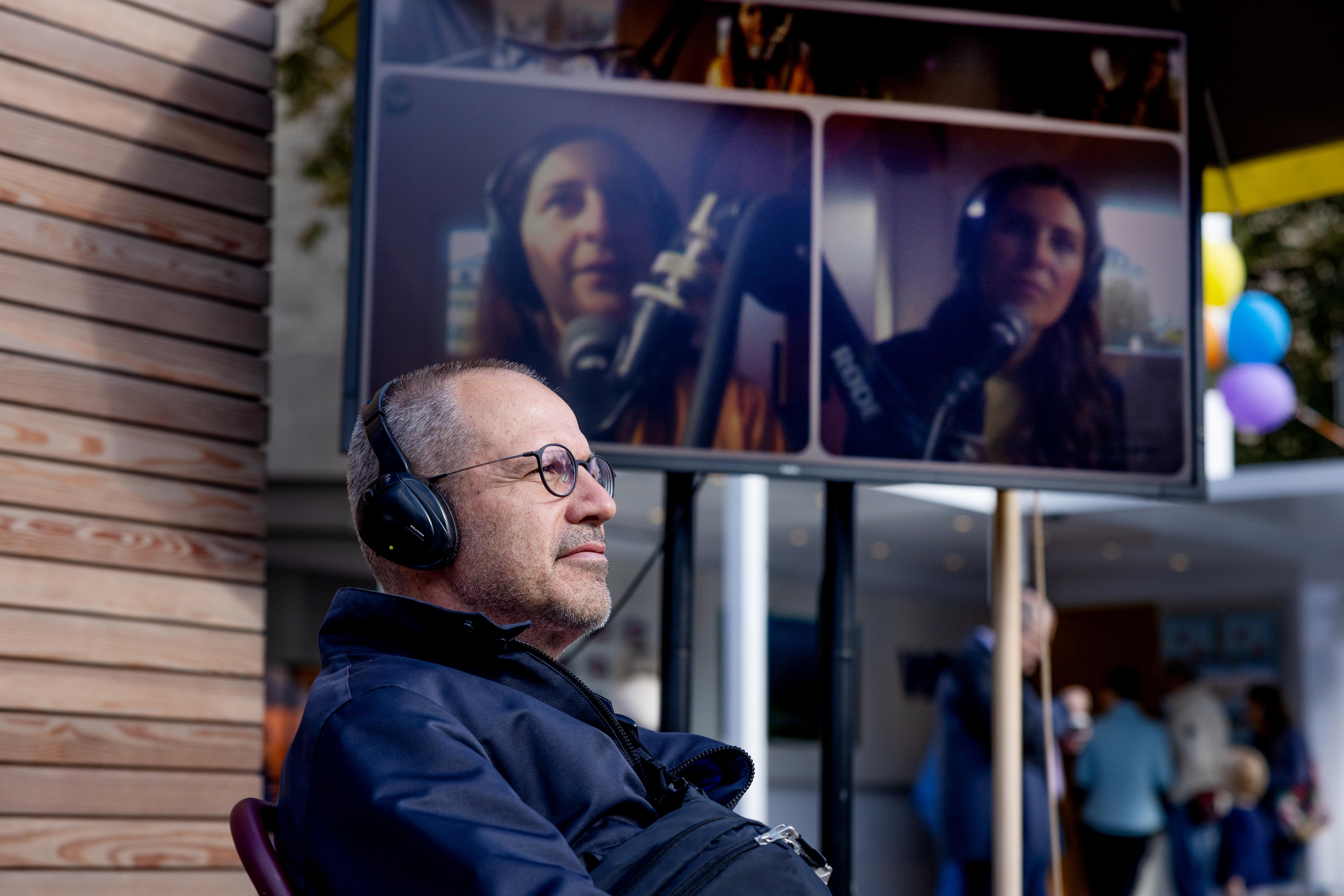 Konzentrierter Besucher mit Kopfhörer vor dem Podcast House