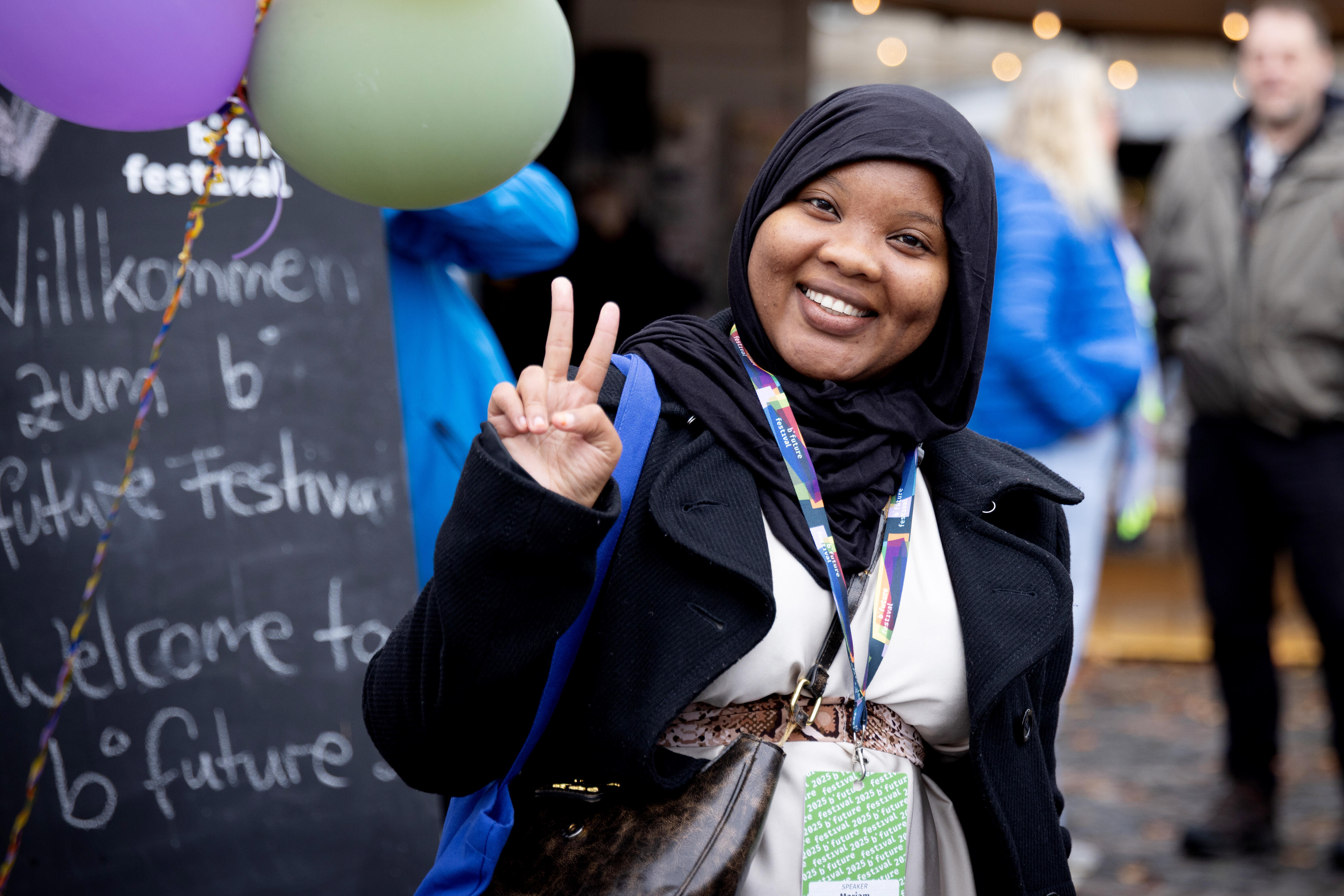 Festivalbesuchende auf dem Münsterplatz, mit Aussteller und Ballons im Hintergrund