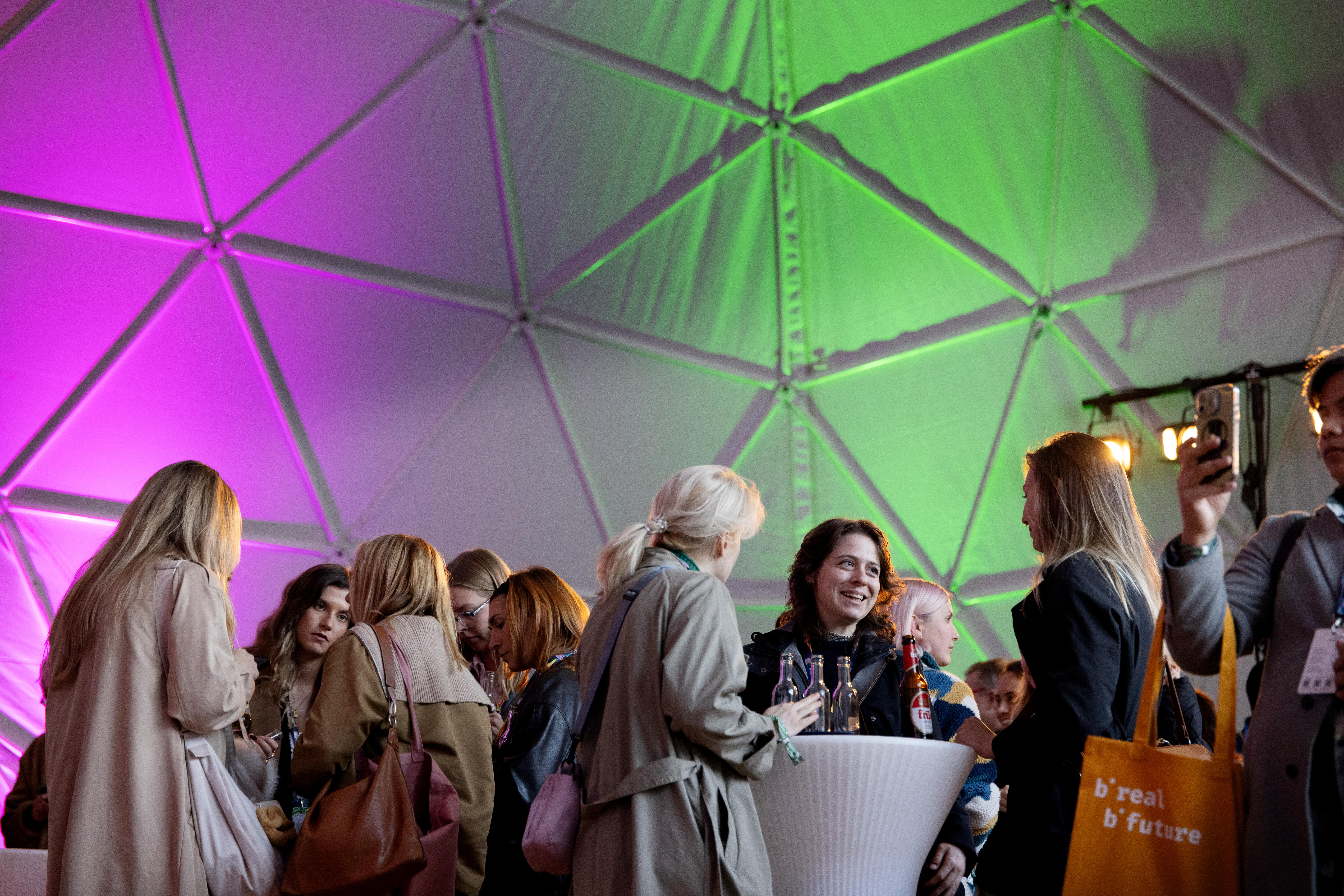 Menschenmasse in einem Zelt. Bunte Lichter im Hintergrund.