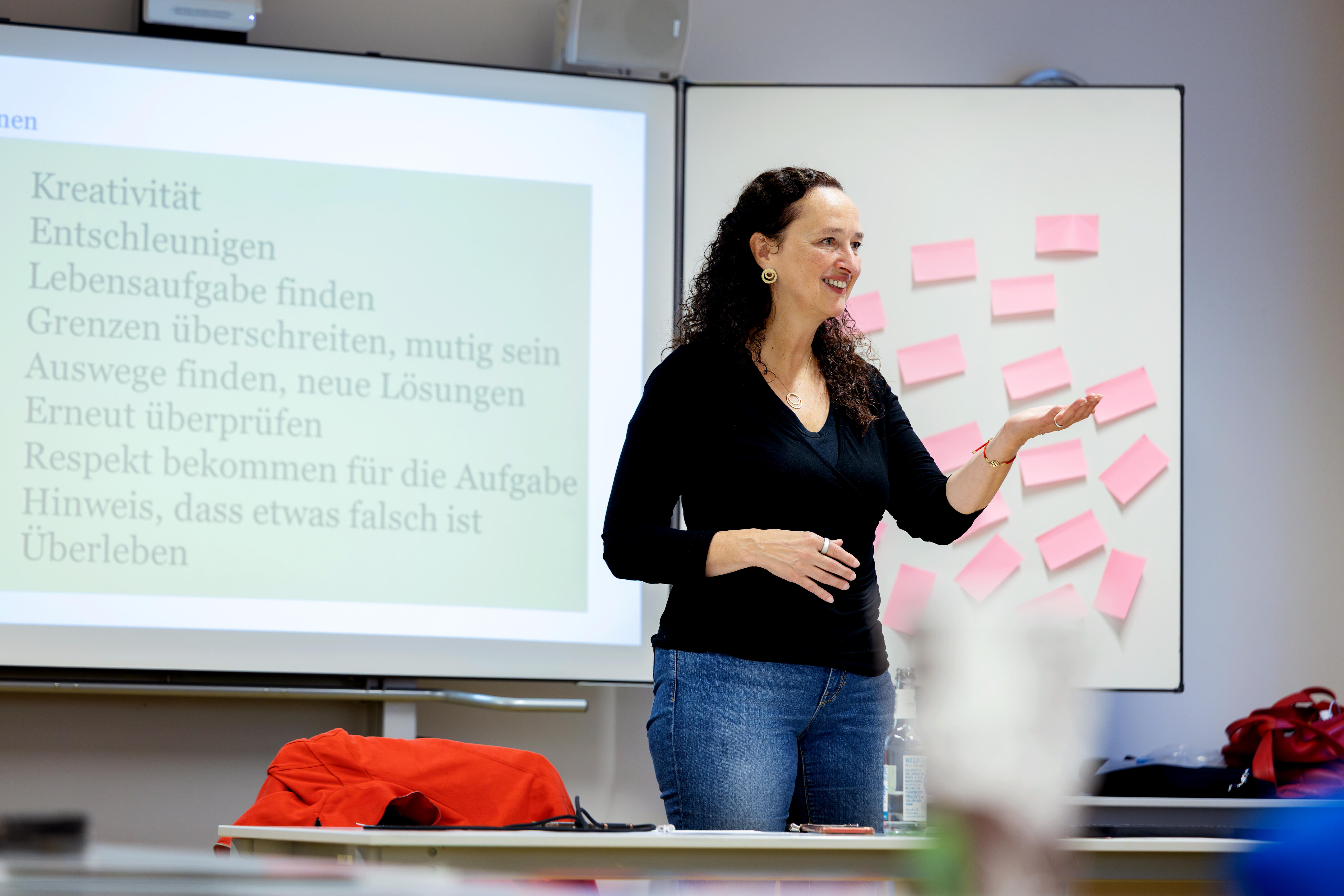 A speaker leading a workshop while standing in front of a whiteboard.
