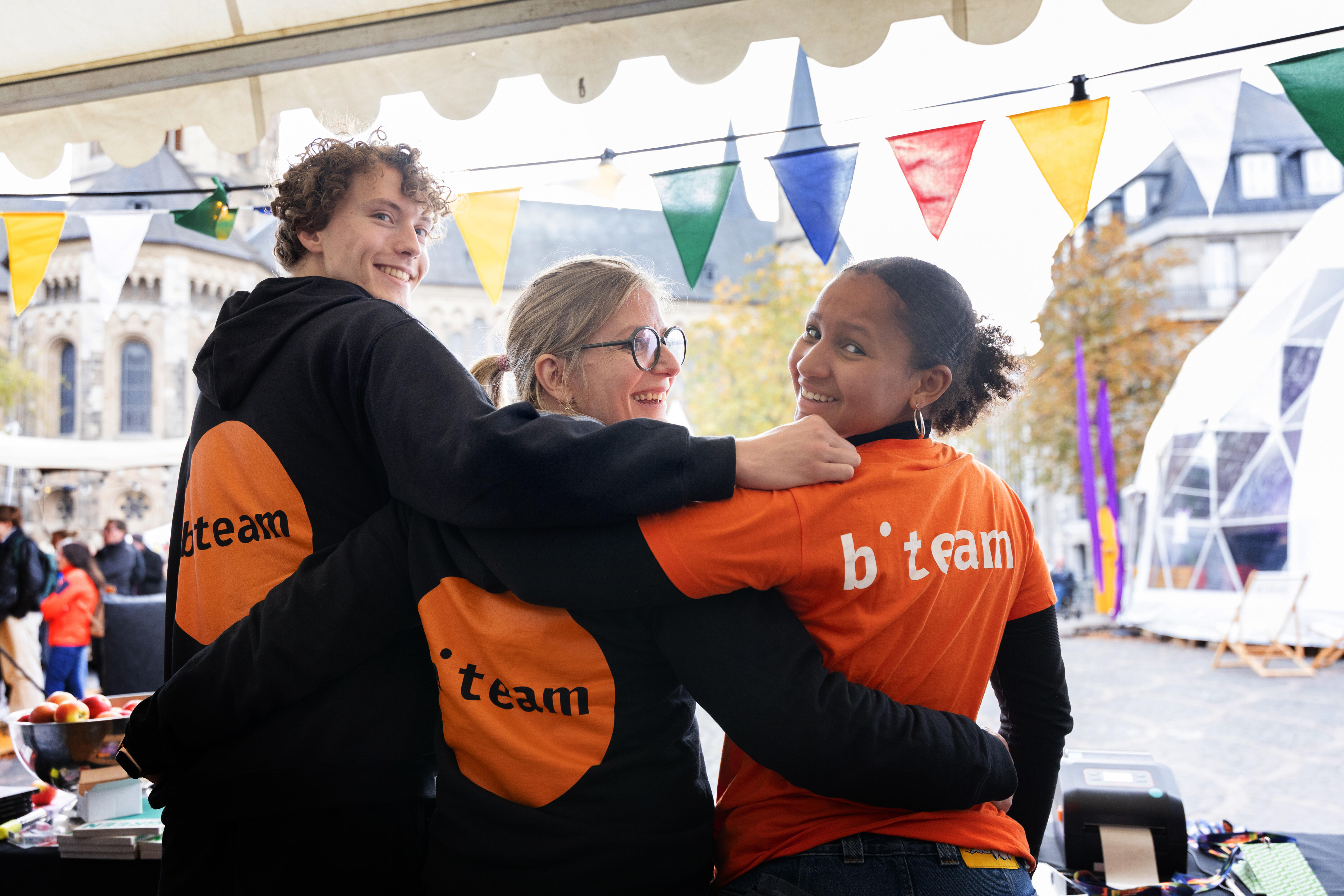 Three b° future festival team members pose on the Münsterplatz in their team gear