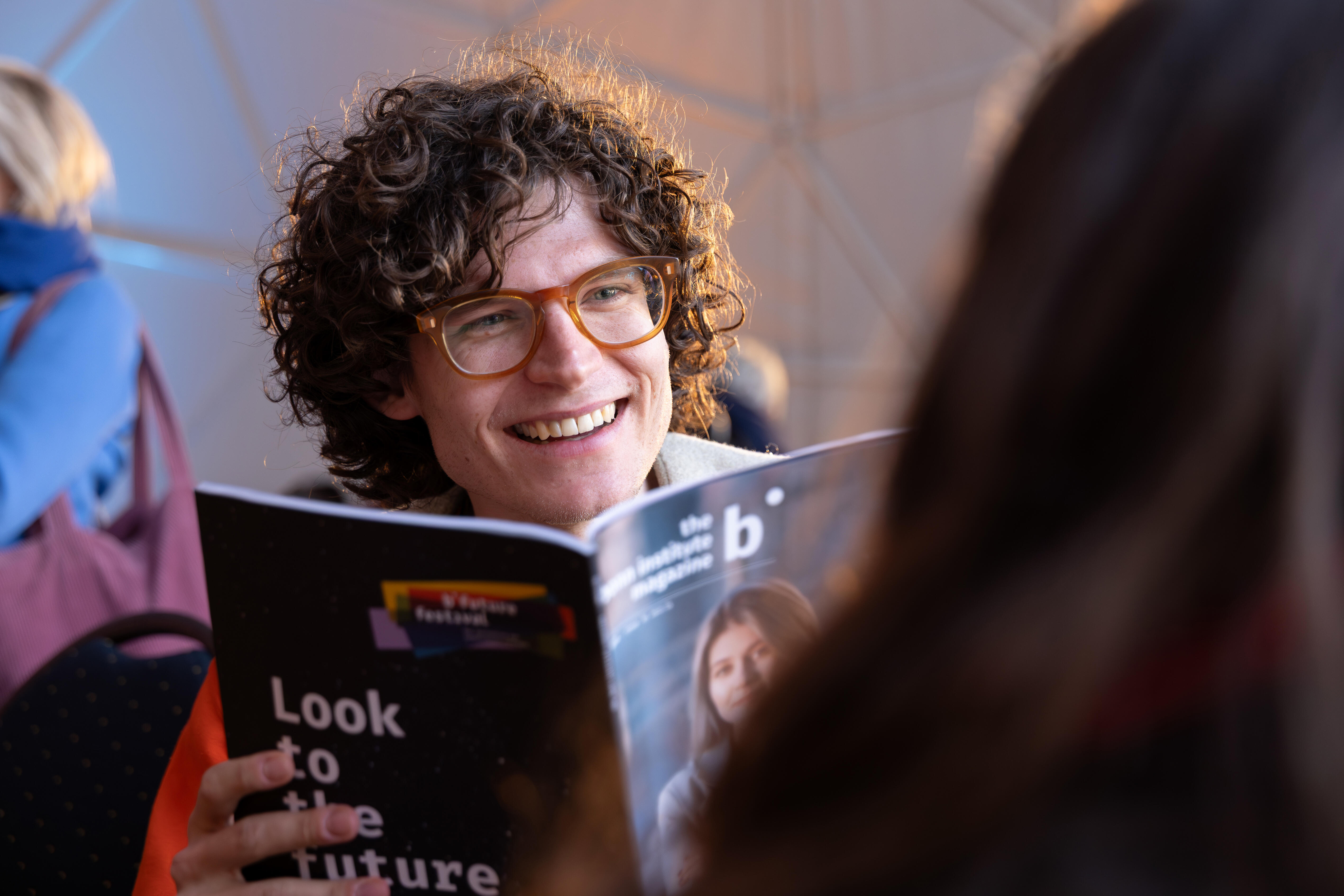 Festivalbesucher hält Programmheft in der Hand