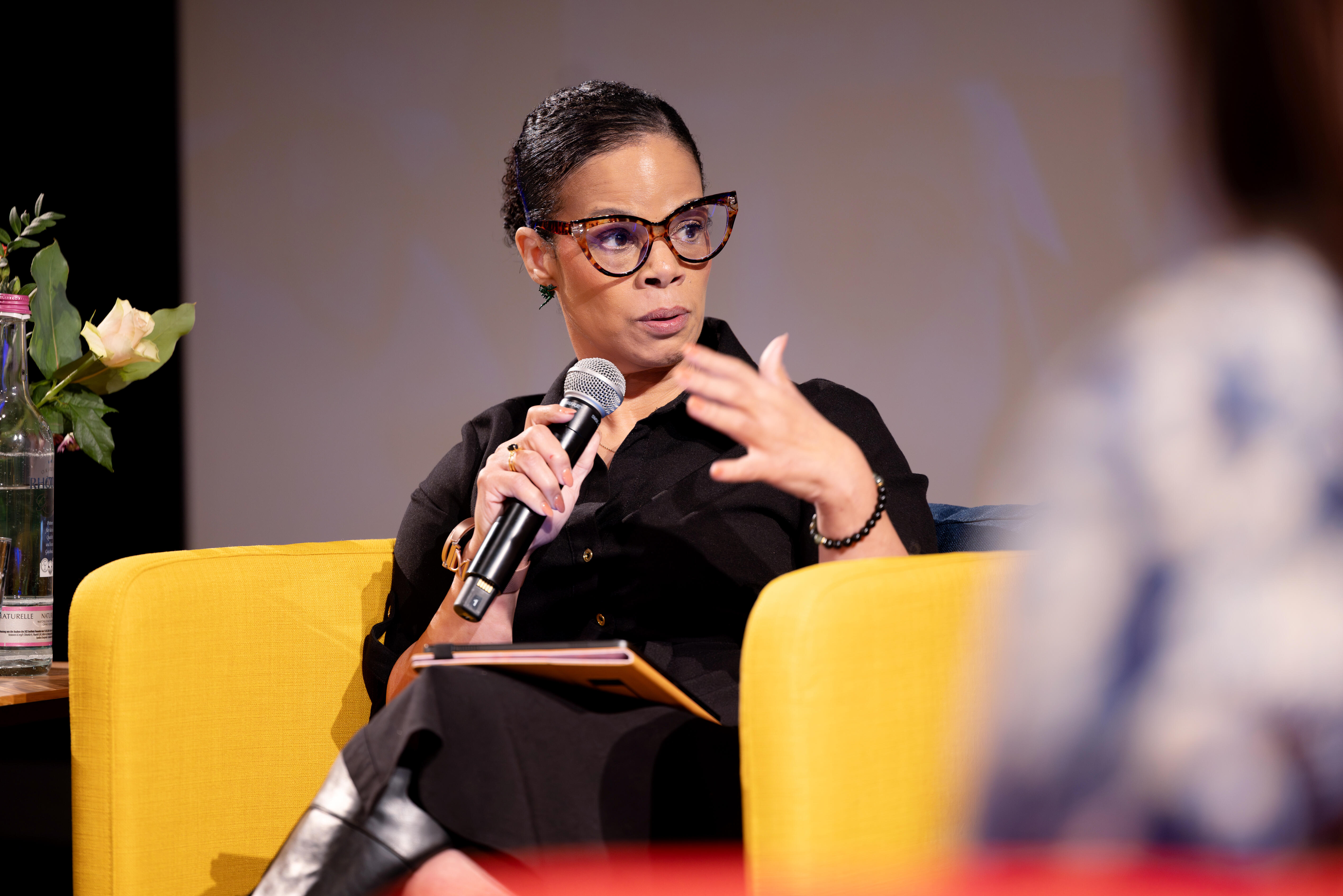 Speakerin auf gelbem Sessel