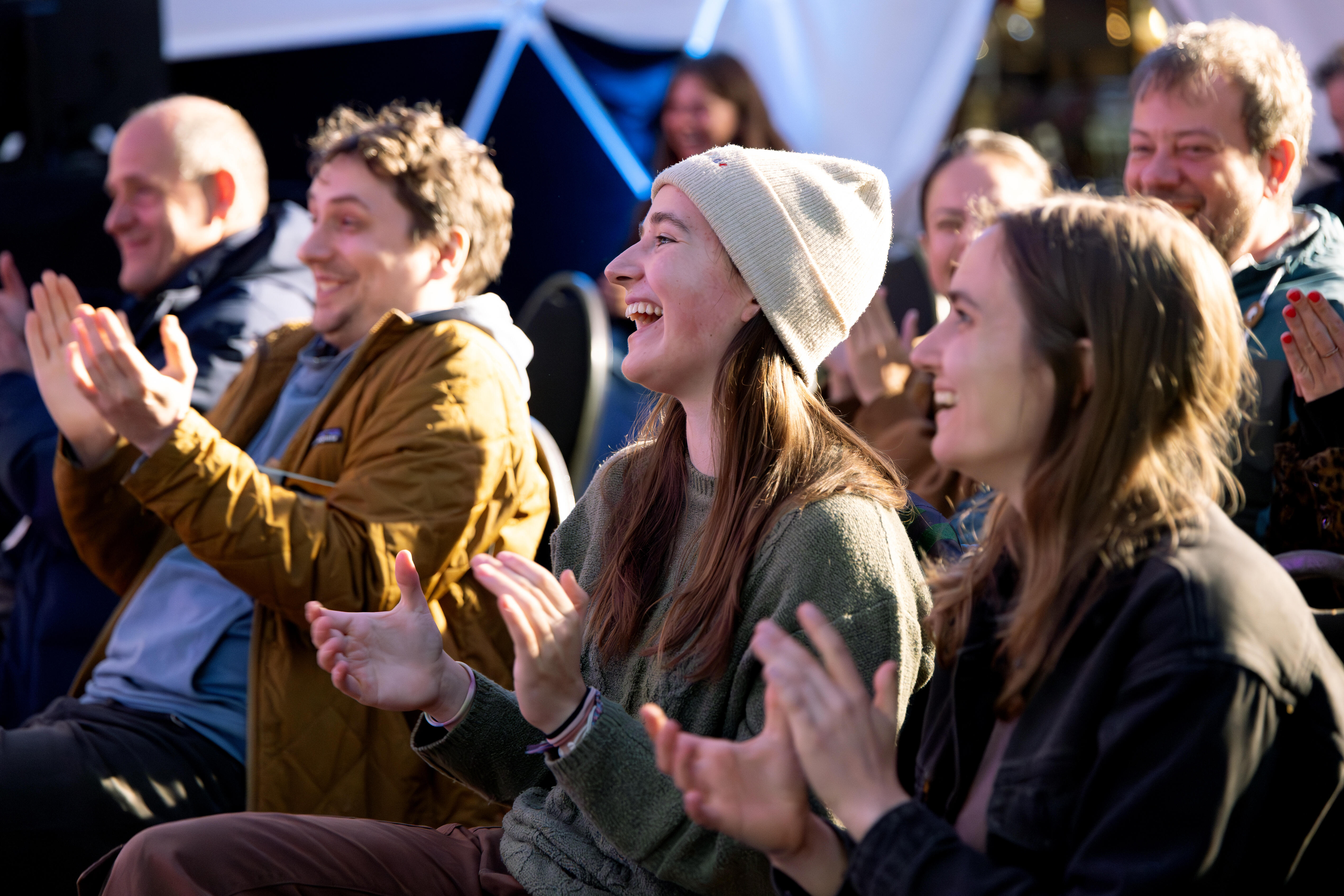 Zuschauende einer Veranstaltung des b° future festivals klatschen und lachen